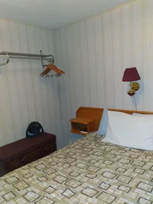 a bedroom with a bed and a lamp and a table at AppleTree Inn in Radium Hot Springs