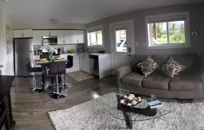 a living room with a couch and a kitchen at Cowichan Calling in Lake Cowichan