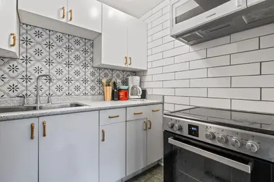 a kitchen with white cabinets and a stove top oven at 4 Bedroom 4 Bathroom 2 Kitchen House in Bridlewood in Calgary