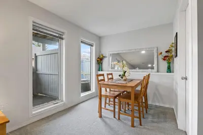 a dining room with a table and chairs and windows at 4 Bedroom 4 Bathroom 2 Kitchen House in Bridlewood in Calgary