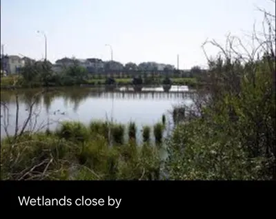 a view of a body of water withwetlands close byrophe at 4 Bedroom 4 Bathroom 2 Kitchen House in Bridlewood in Calgary