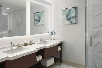 a bathroom with two sinks and a shower at Delta Hotels by Marriott Burnaby Conference Centre in Burnaby