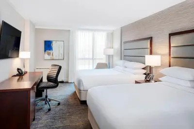 a hotel room with two beds and a desk at Delta Hotels by Marriott Burnaby Conference Centre in Burnaby