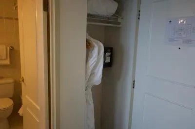 a bathroom with a closet with a person in a robe at Century Plaza Hotel in Vancouver