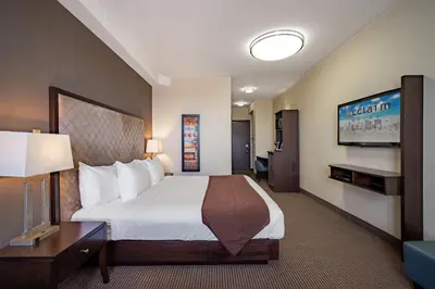 a hotel room with a bed and a flat screen tv at Acclaim Hotel by CLIQUE in Calgary