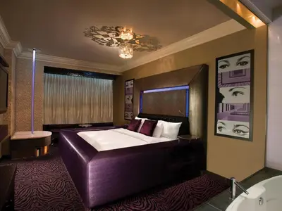 a bedroom with a large bed and a bathroom at Fantasyland Hotel in Edmonton