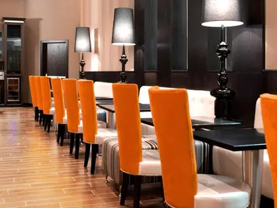 a dining room with orange chairs and a table at Fantasyland Hotel in Edmonton