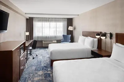 a hotel room with two beds and a desk at Four Points by Sheraton Edmonton South in Edmonton