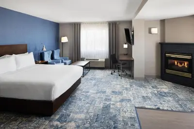 a hotel room with a bed and a fireplace at Four Points by Sheraton Edmonton South in Edmonton