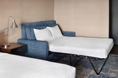 a hotel room with two beds and a chair at Four Points by Sheraton Edmonton South in Edmonton