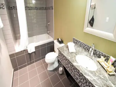 a bathroom with a sink and a toilet and a tub at Sawridge Inn and Conference Centre Edmonton South in Edmonton