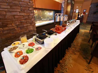 a long table with plates of food on it at Sawridge Inn and Conference Centre Edmonton South in Edmonton
