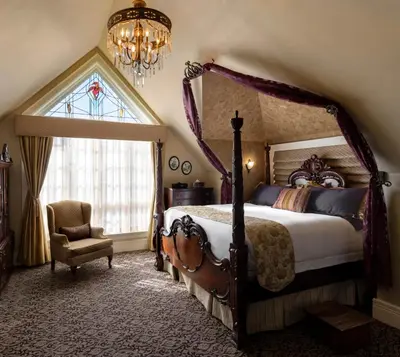 a bedroom with a bed and a chair and a window at Abigail's Hotel in Victoria