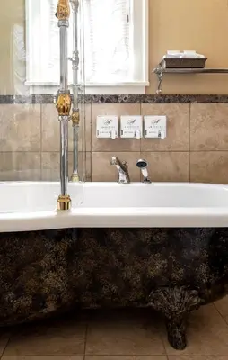 a bath tub in a bathroom with a sink at Abigail's Hotel in Victoria