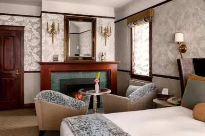 a room with a fireplace and chairs and a bed at Abigail's Hotel in Victoria