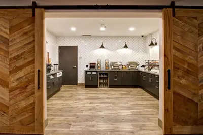 a large kitchen with black cabinets and a wooden door at Canalta Lodge in Banff