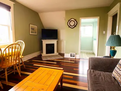 a living room with a table and a fireplace at James Bay Inn Hotel, Suites & Cottage in Victoria