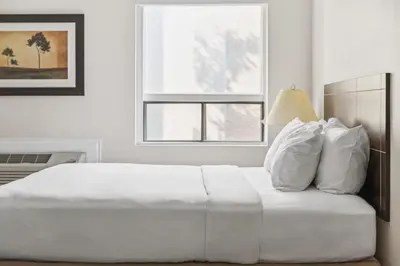 a white bed in a white bedroom with a window at Radisson Hotel & Conference Centre Edmonton in Edmonton