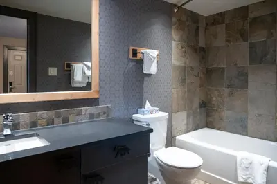 a bathroom with a sink and a toilet and a tub at Banff Rocky Mountain Resort in Banff