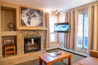 a living room with a fireplace and a tv at Banff Rocky Mountain Resort in Banff