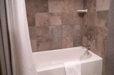 a bathroom with a white bath tub with a shower curtain at Banff Rocky Mountain Resort in Banff