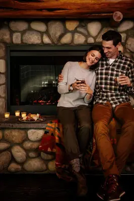 a man and a woman sitting in front of a fireplace at Forest Park Hotel in Jasper