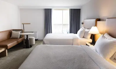 a hotel room with two beds and a couch at Forest Park Hotel in Jasper