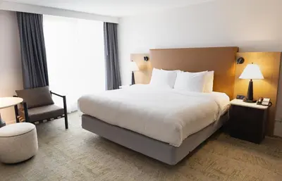a hotel room with a large bed and a chair at Forest Park Hotel in Jasper