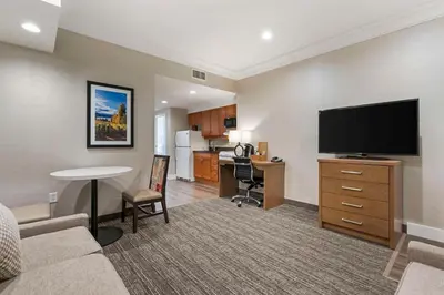 a living room with a couch and a flat screen tv at Best Western Plus Kelowna Hotel & Suites in Kelowna