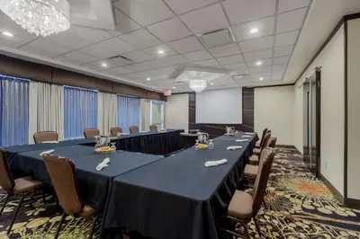 a conference room with a long table and chairs at Best Western Premier Denham Inn & Suites in Leduc