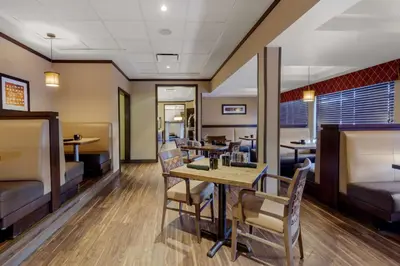 a dining room with tables and chairs in a restaurant at Best Western Premier Denham Inn & Suites in Leduc