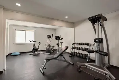 a gym with several exercise equipment in a room at Days Inn by Wyndham Kelowna in Kelowna