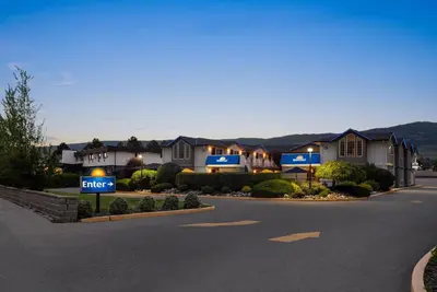a house with a hotel sign in front of a street at Days Inn by Wyndham Kelowna in Kelowna