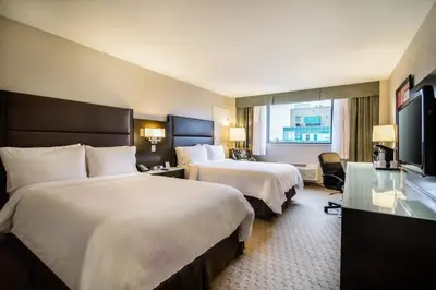 a hotel room with two beds and a television at Holiday Inn Vancouver-Centre Broadway by IHG in Vancouver