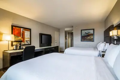 a hotel room with two beds and a desk at Holiday Inn Vancouver-Centre Broadway by IHG in Vancouver