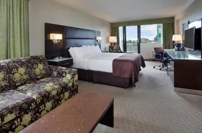 a hotel room with a bed and a couch at Holiday Inn Vancouver-Centre Broadway by IHG in Vancouver