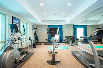 a gym with treadmills and exercise equipment and a mirror at Sandman Hotel and Suites Squamish in Squamish