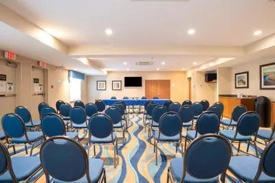 a conference room with blue chairs and a podium at Sandman Hotel and Suites Squamish in Squamish