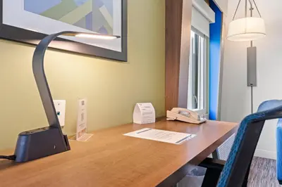 a desk with a computer and a lamp on it at Holiday Inn Express and Suites Surrey by IHG in Surrey