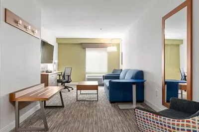 a living room with a blue couch and a table at Holiday Inn Express and Suites Surrey by IHG in Surrey