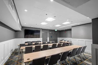 a conference room with tables and chairs and a screen at Holiday Inn Hotel & Suites Surrey East - Cloverdale by IHG in Surrey