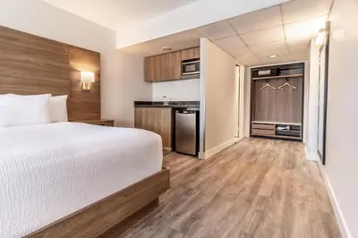 a hotel room with a bed and a kitchen at Atrium Hotel Vancouver in Vancouver