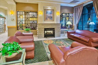 a living room with leather furniture and a fireplace at Holiday Inn & Suites North Vancouver by IHG in North Vancouver
