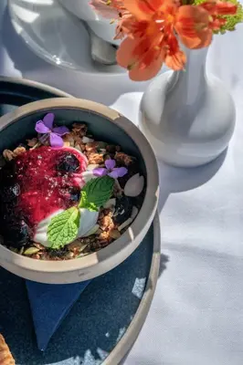a bowl of food sitting on a table with flowers at The Magnolia Hotel & Spa in Victoria