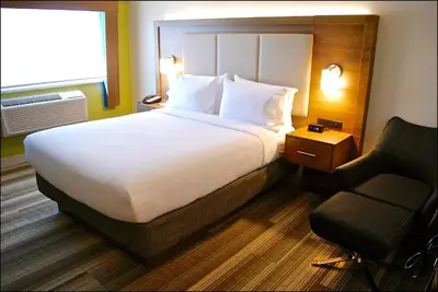 a hotel room with a large bed and a chair at Holiday Inn Express Vancouver Airport-Richmond by IHG in Richmond