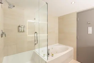 a bathroom with a tub and a glass shower at Holiday Inn Express Vancouver Airport-Richmond by IHG in Richmond