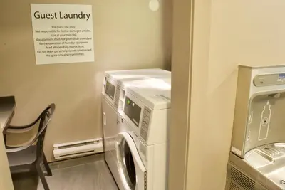 a washing machine in a laundry room with a chair at Holiday Inn Vancouver Airport Richmond by IHG in Richmond