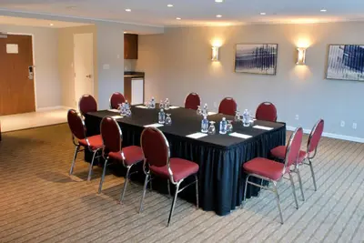 a conference room with a black table and red chairs at Holiday Inn Vancouver Airport Richmond by IHG in Richmond