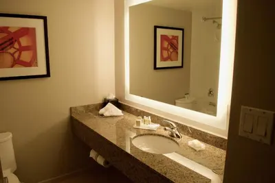 a bathroom with a sink and a large mirror at Holiday Inn Vancouver Airport Richmond by IHG in Richmond