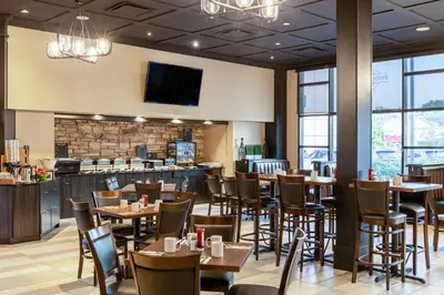 a restaurant with tables and chairs and a bar at Holiday Inn Vancouver Airport Richmond by IHG in Richmond